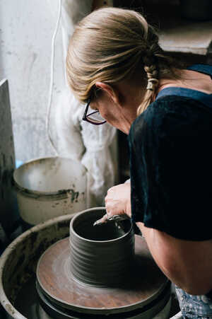 Potter throwing jug on pottery wheel Potter throwing jug on pottery wheel