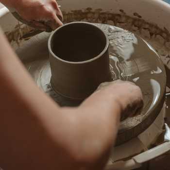 Arms taking cup off pottery wheel Arms taking cup off pottery wheel
